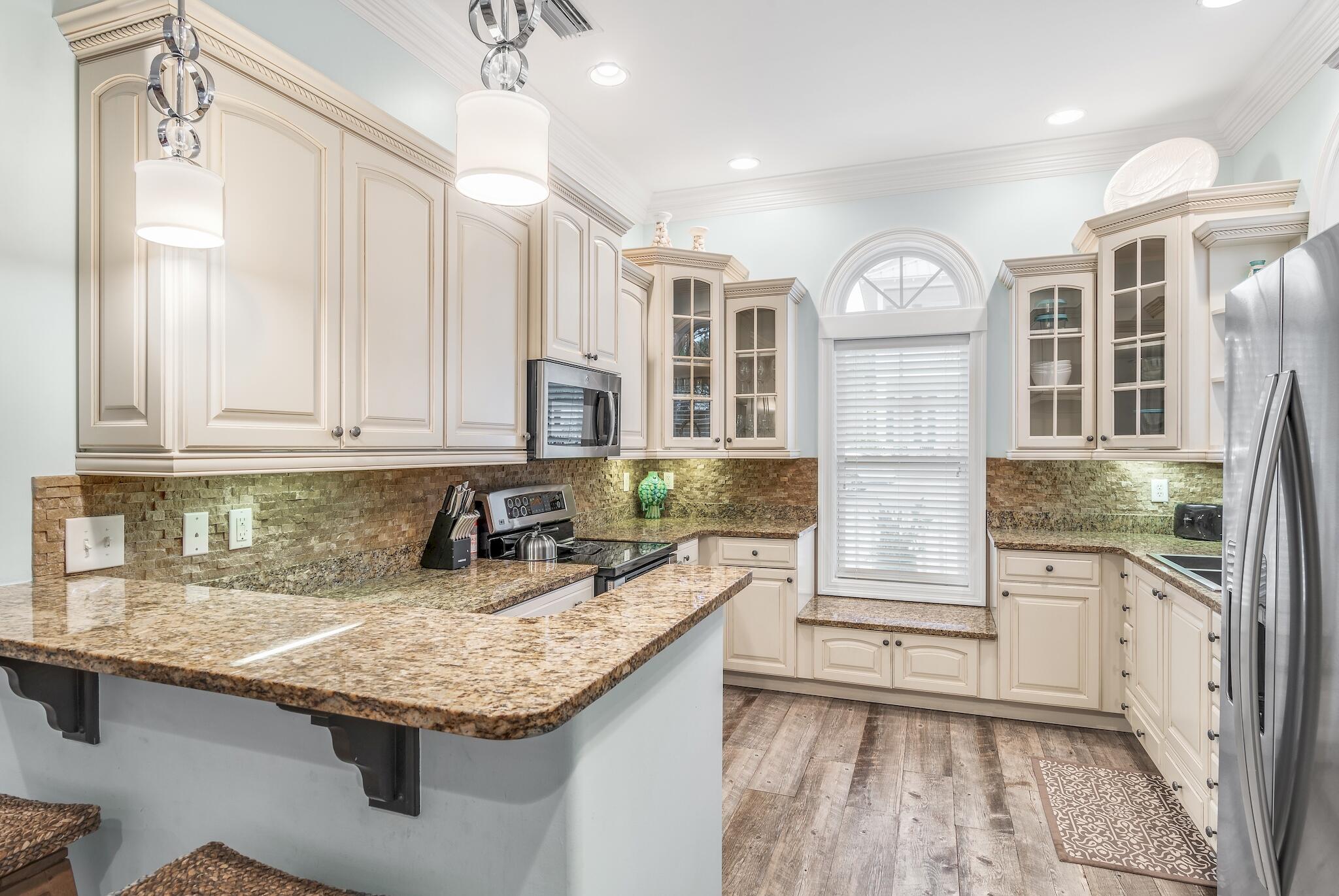 55 The Greenway Loop Panama City Beach, FL 32461 - Photo 11 of 32 a kitchen with granite countertop a sink and a stove top oven