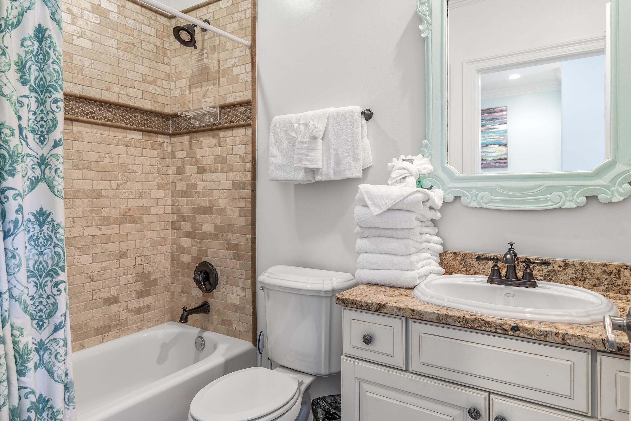 55 The Greenway Loop Panama City Beach, FL 32461 - Photo 14 of 32 a bathroom with a granite countertop sink a toilet a mirror and bathtub