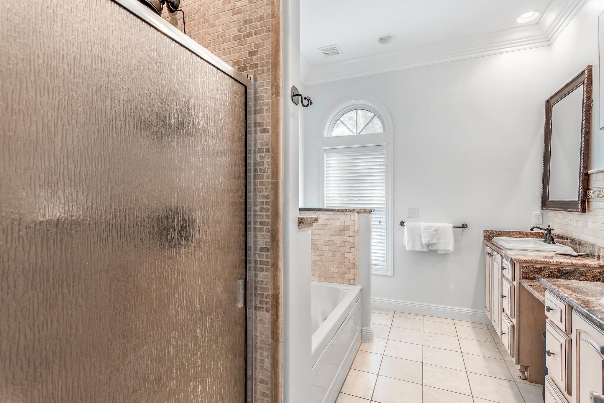 55 The Greenway Loop Panama City Beach, FL 32461 - Photo 18 of 32 a bathroom with a bathtub sink vanity and mirror
