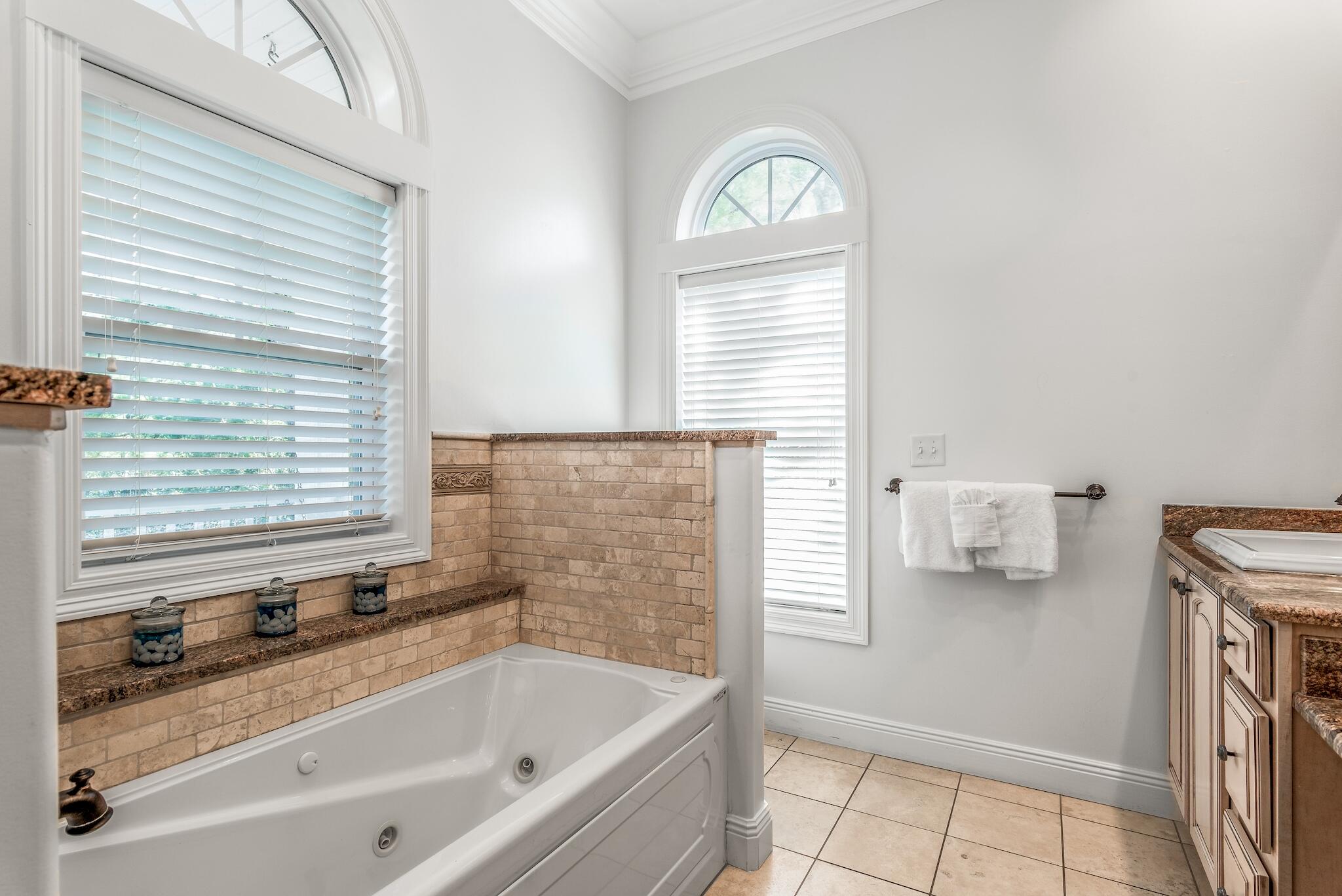55 The Greenway Loop Panama City Beach, FL 32461 - Photo 19 of 32 a bathroom with a bathtub and next to a window