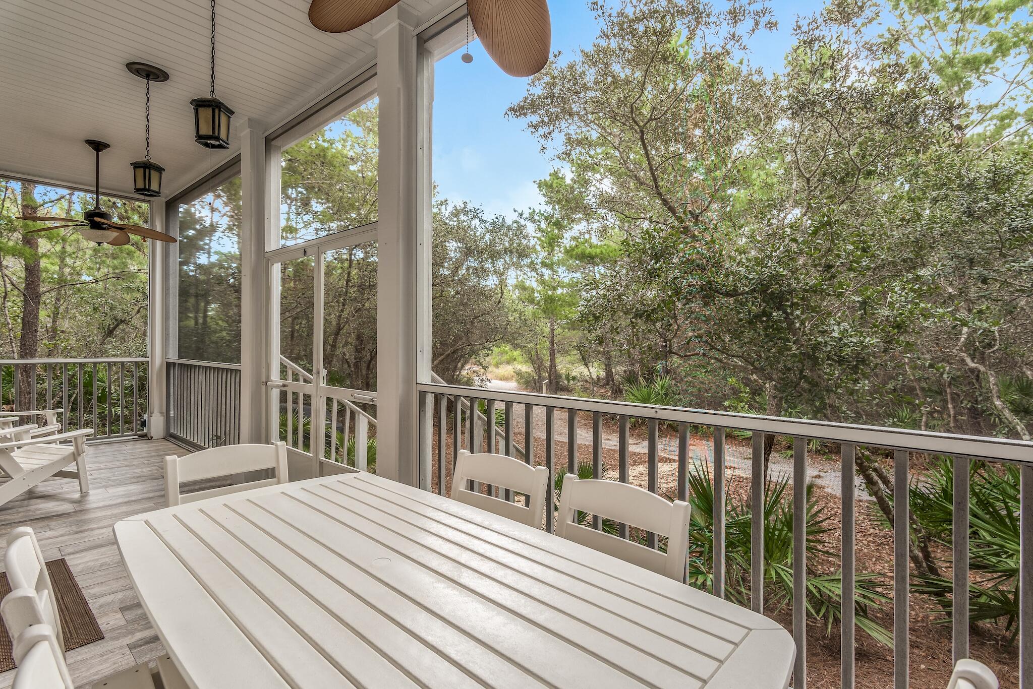 55 The Greenway Loop Panama City Beach, FL 32461 - Photo 2 of 32 a balcony with wooden floor table and chairs