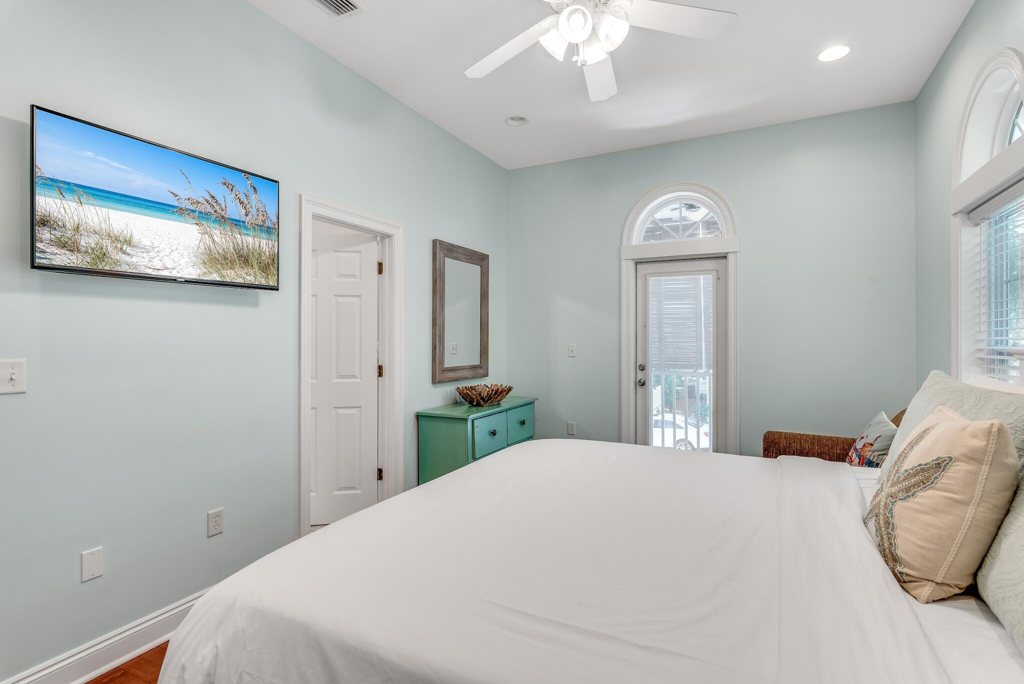 55 The Greenway Loop Panama City Beach, FL 32461 - Photo 23 of 32 a bedroom with a large bed and a chandelier