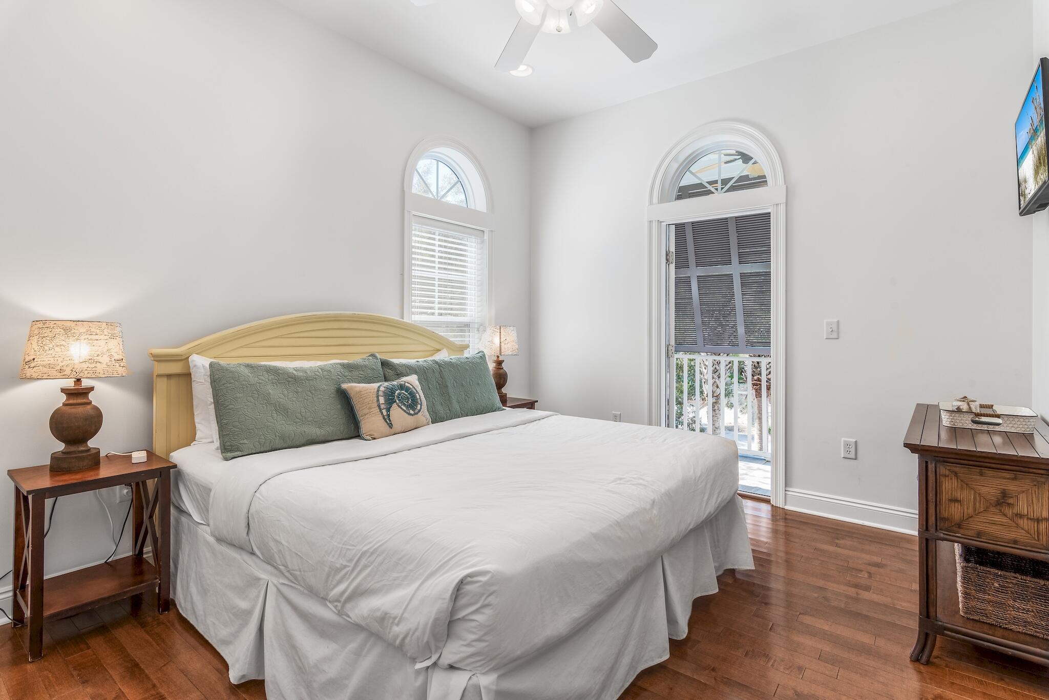 55 The Greenway Loop Panama City Beach, FL 32461 - Photo 27 of 32 a bedroom with a bed a mirror and a window