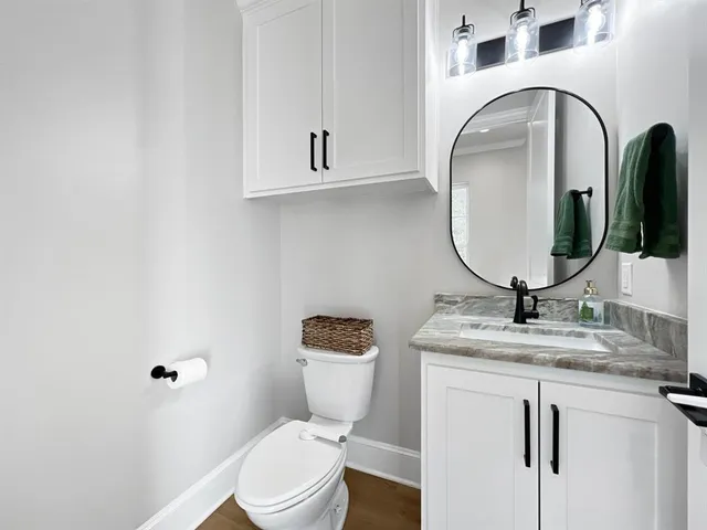 a bathroom with a toilet sink and mirror