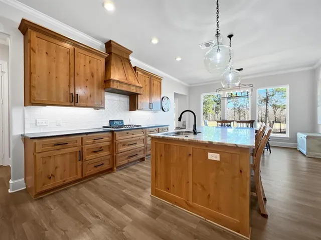 a kitchen with stainless steel appliances granite countertop a stove and cabinets