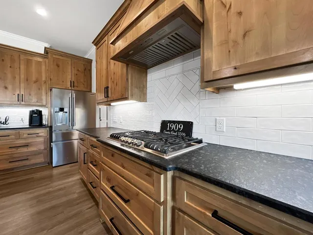 a kitchen with stainless steel appliances granite countertop a stove and a refrigerator