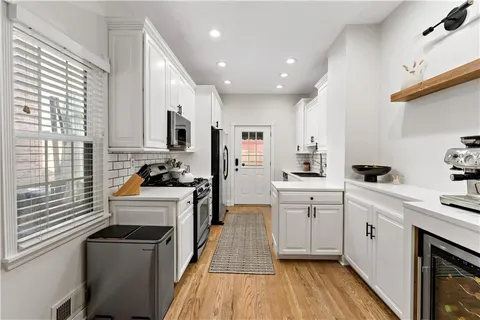 a kitchen with white cabinets and appliances