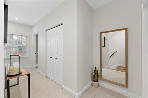 a bedroom with a bed mirror and a window