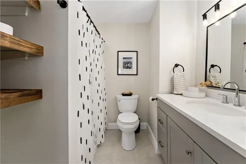 a bathroom with a toilet a sink and mirror
