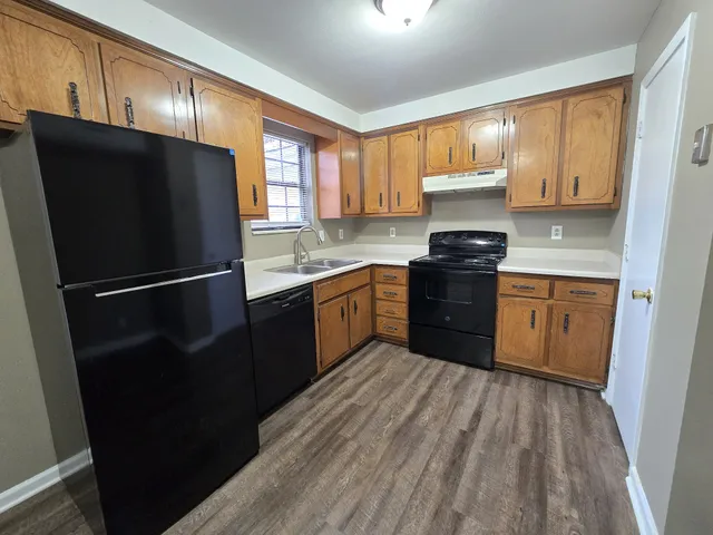 a kitchen with a sink a refrigerator and cabinets