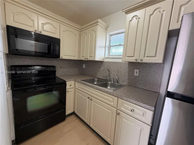 a kitchen with stainless steel appliances granite countertop a stove microwave and sink