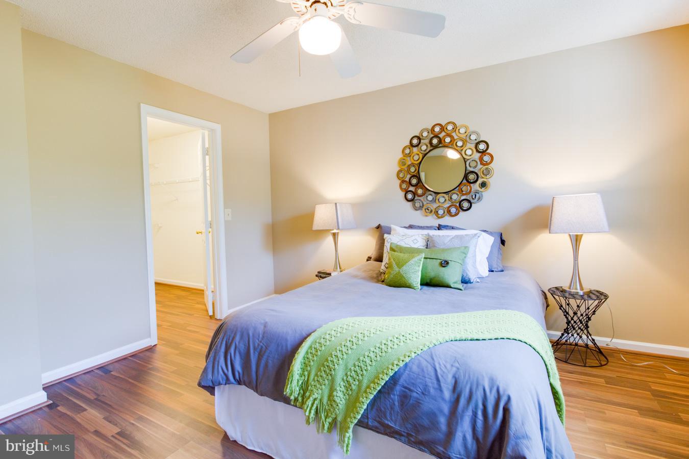 12016 Taliesin Place, Unit 34 Reston, VA 20190 - Photo 13 of 30 a bedroom with a bed and wooden floor
