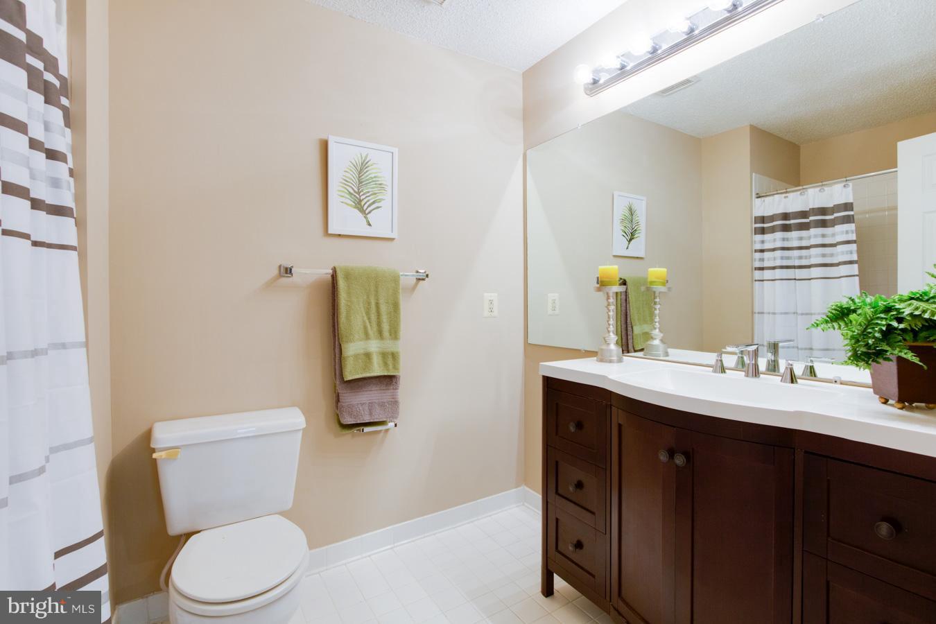12016 Taliesin Place, Unit 34 Reston, VA 20190 - Photo 16 of 30 a bathroom with a granite countertop toilet sink and mirror