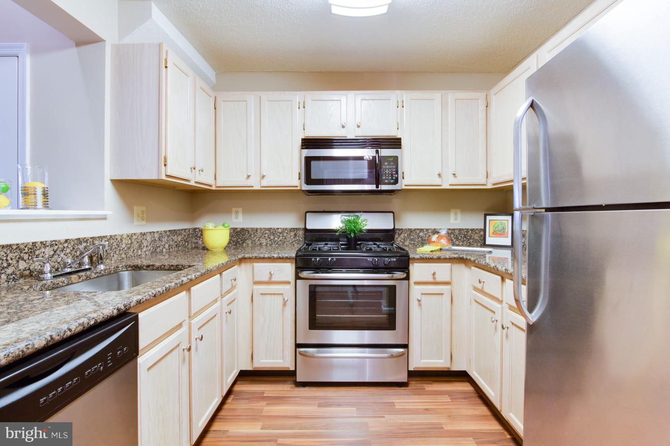 12016 Taliesin Place, Unit 34 Reston, VA 20190 - Photo 7 of 30 a kitchen with stainless steel appliances granite countertop a refrigerator stove and sink
