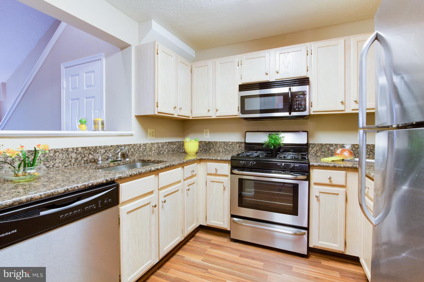12016 Taliesin Place, Unit 34 Reston, VA 20190 - Photo 8 of 30 a kitchen with stainless steel appliances granite countertop a stove a sink and a refrigerator