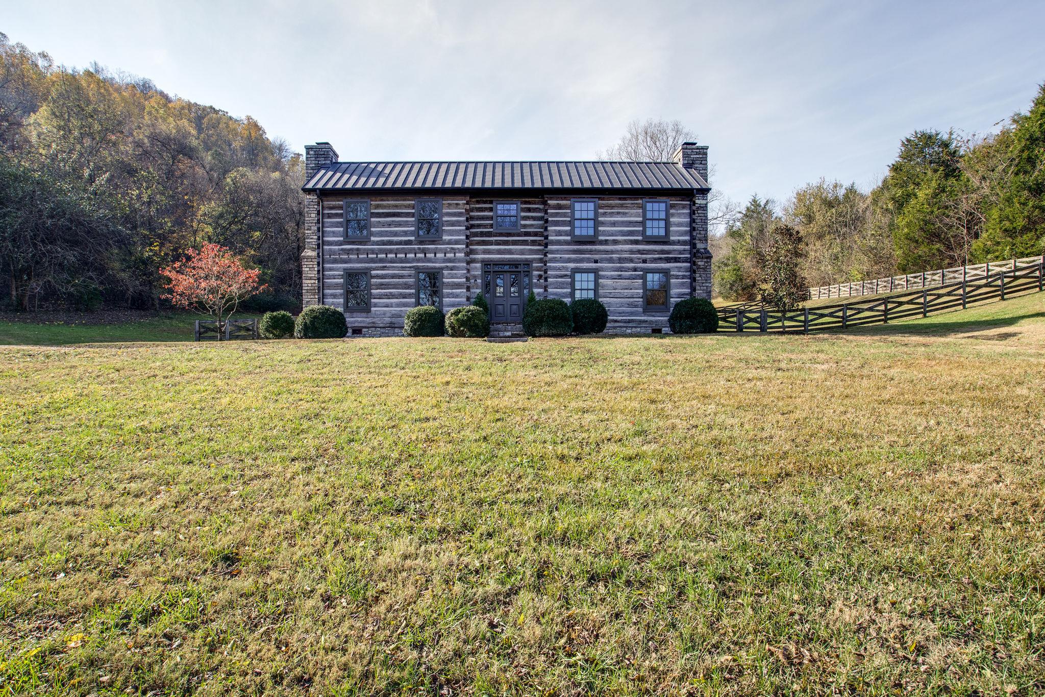 a brick house with a large yard next to a yard
