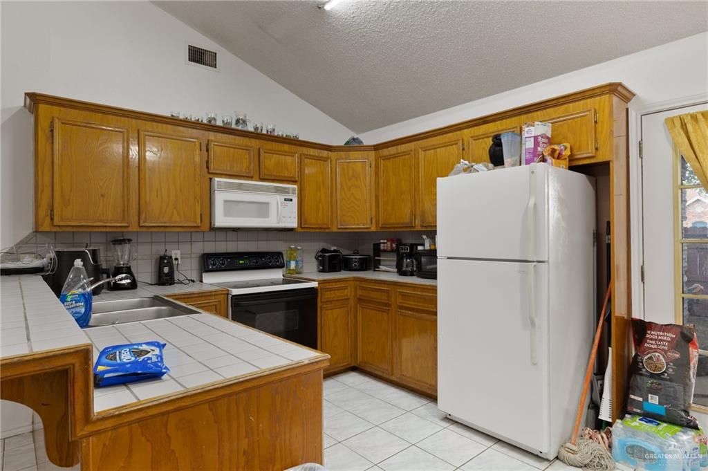 300 North Coyote Boulevard La Joya, TX 78560 - Photo 8 of 24 a kitchen with stainless steel appliances granite countertop a refrigerator sink stove and white cabinets