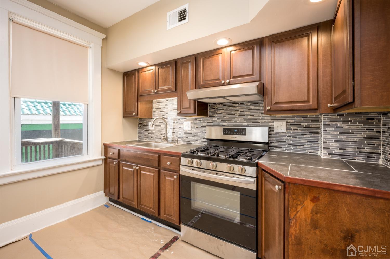 120 Rector Street Perth Amboy, NJ 08861 - Photo 3 of 34 a kitchen with stainless steel appliances granite countertop a stove a sink and a microwave