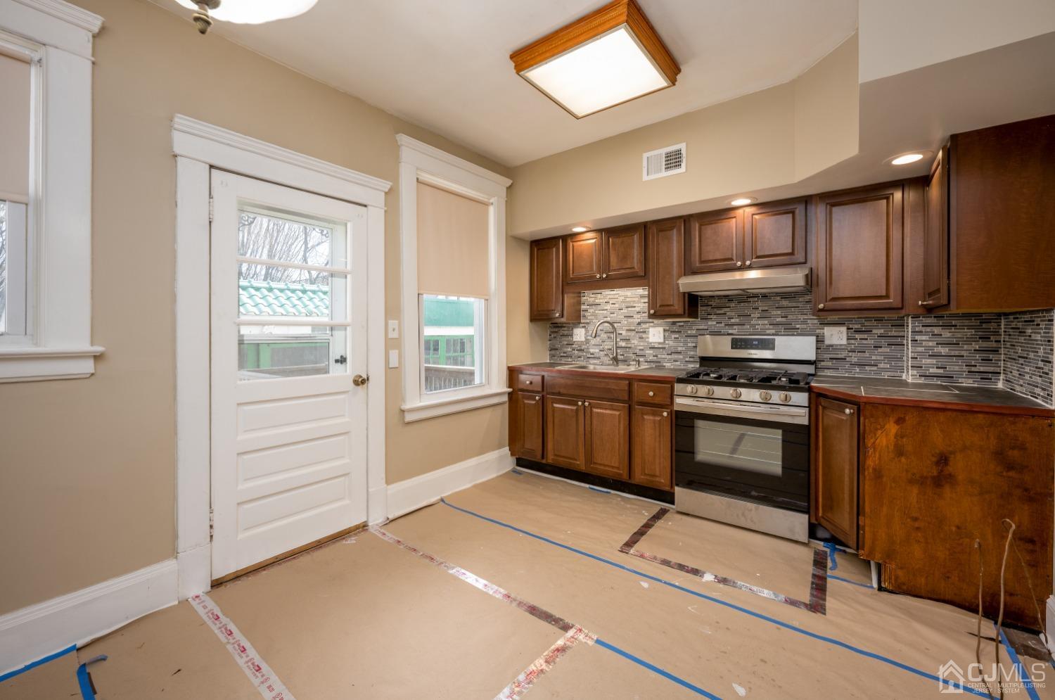 120 Rector Street Perth Amboy, NJ 08861 - Photo 4 of 34 a kitchen with stainless steel appliances kitchen island granite countertop a stove a sink and a microwave