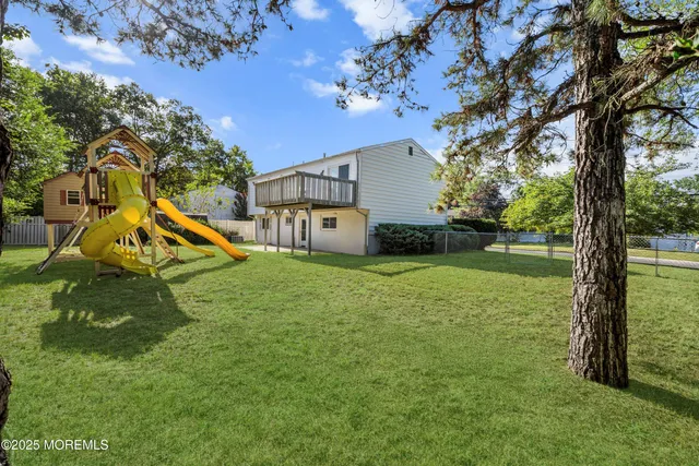 a view of a house with a backyard and a tree