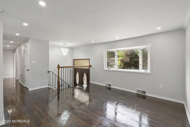 a view of a room with wooden floor and a window