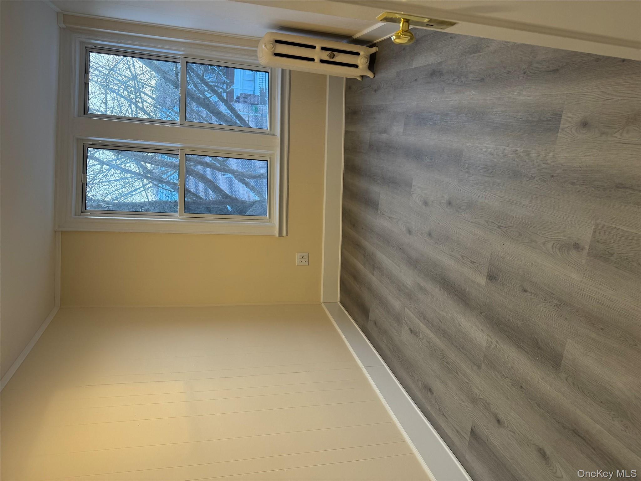 106-17 Metropolitan Avenue, Unit 1 Queens, NY 11375 - Photo 1 of 5 a view of room with window and wooden floor