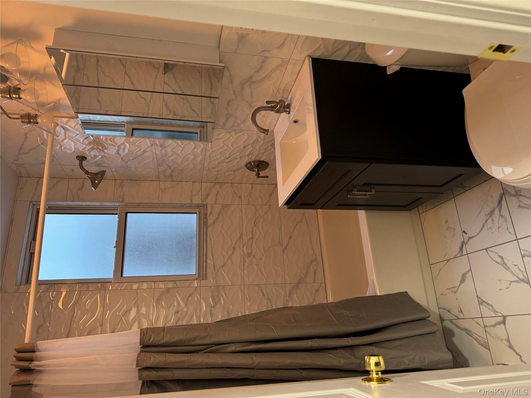 106-17 Metropolitan Avenue, Unit 1 Queens, NY 11375 - Photo 4 of 5 a bathroom with a sink a toilet a tub and shower