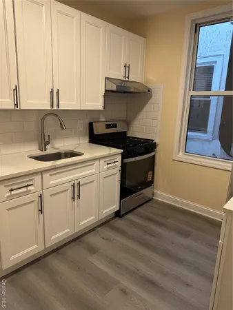 a kitchen with stainless steel appliances granite countertop a sink stove and cabinets