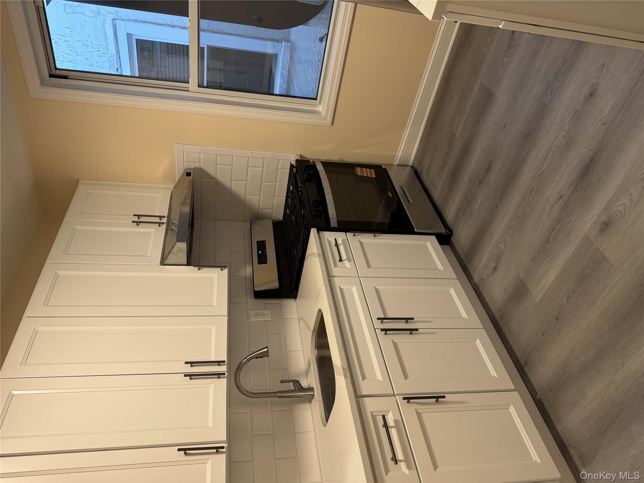 106-17 Metropolitan Avenue, Unit 1 Queens, NY 11375 - Photo 5 of 5 a kitchen with stainless steel appliances granite countertop a sink stove and cabinets
