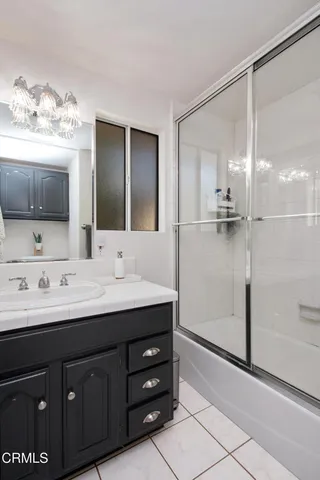a bathroom with a double vanity sink mirror and shower