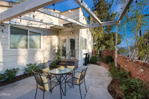 a view of patio with a table and chairs and potted plants