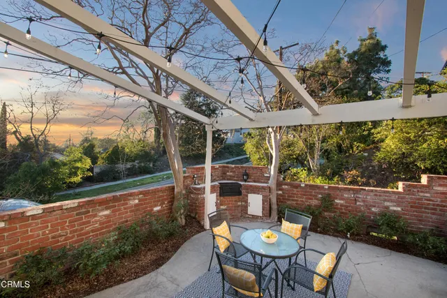 a view of a patio with table and chairs potted plants with wooden floor and fence