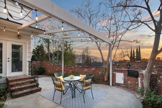 a view of a patio with a table chairs and a backyard