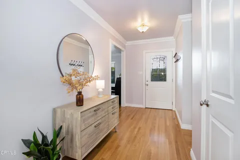 a view of a hallway to a livingroom with wooden floor