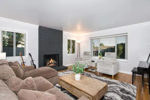 a living room with furniture fireplace and a large window