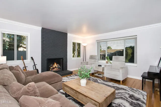 a living room with furniture fireplace and a large window