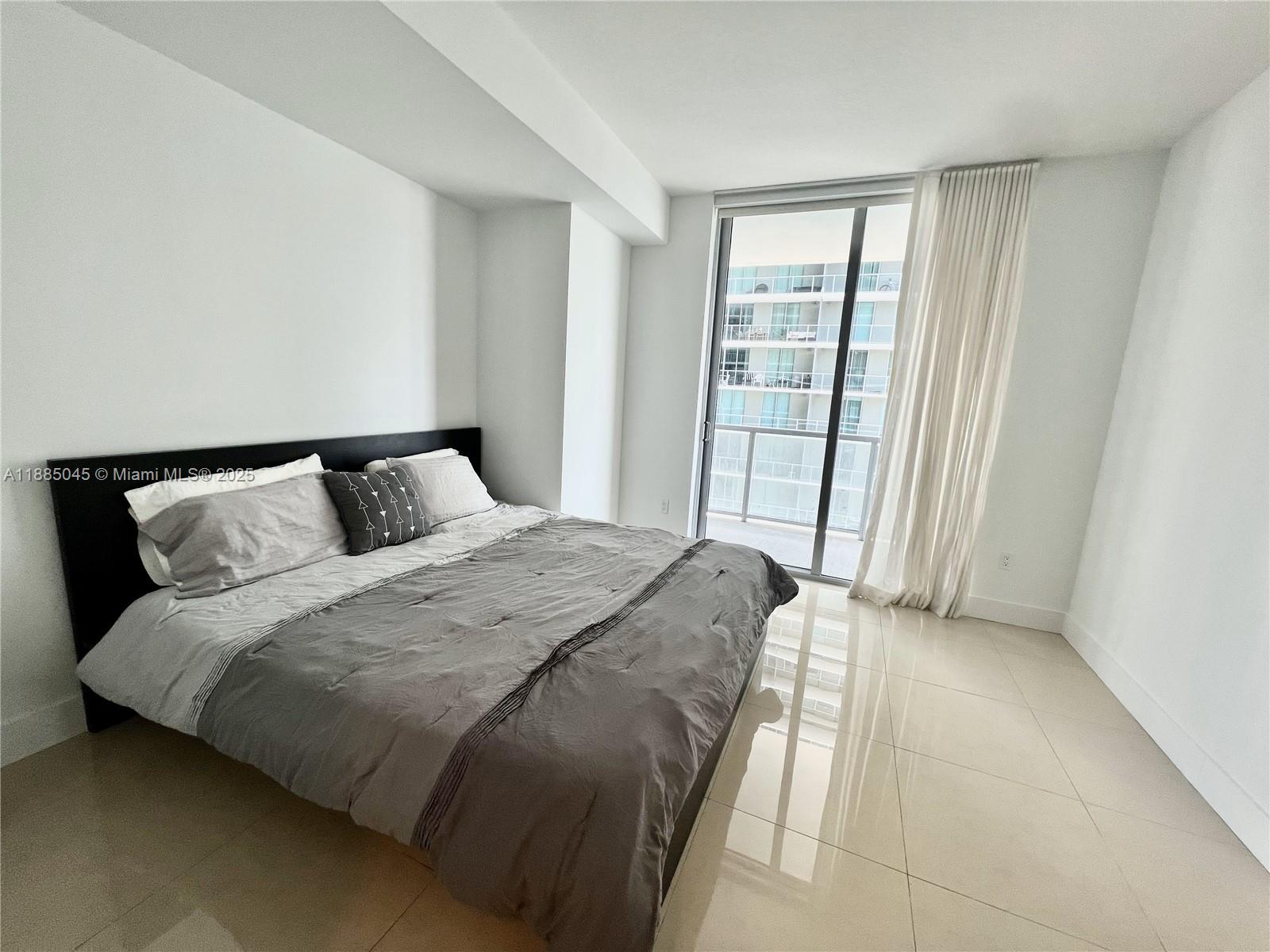 1111 Southwest 1st Avenue, Unit 1914 Miami, FL 33130 - Photo 12 of 31 a bedroom with a bed and wooden floor