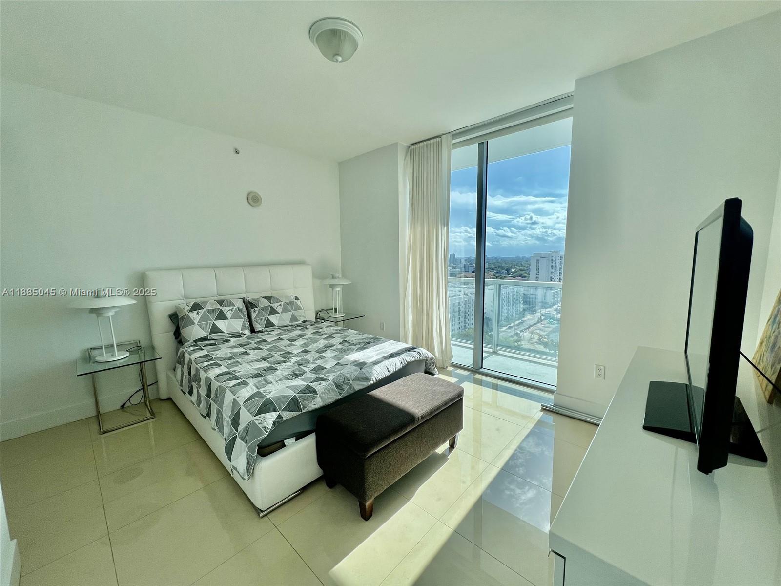 1111 Southwest 1st Avenue, Unit 1914 Miami, FL 33130 - Photo 9 of 31 a bed sitting in a bedroom next to a window