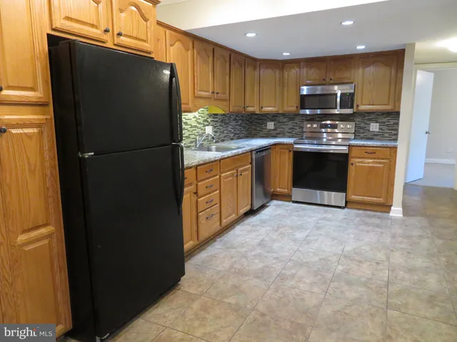 a kitchen with stainless steel appliances granite countertop a refrigerator and a stove top oven