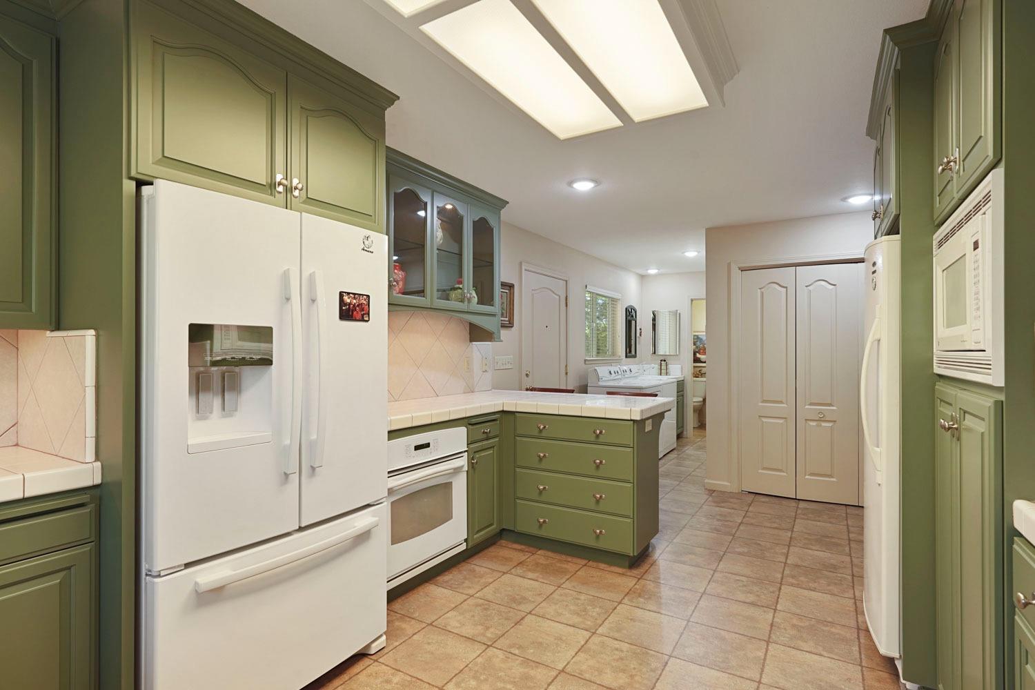 14267 East Peltier Road Acampo, CA 95220 - Photo 21 of 65 a kitchen with white cabinets and white appliances