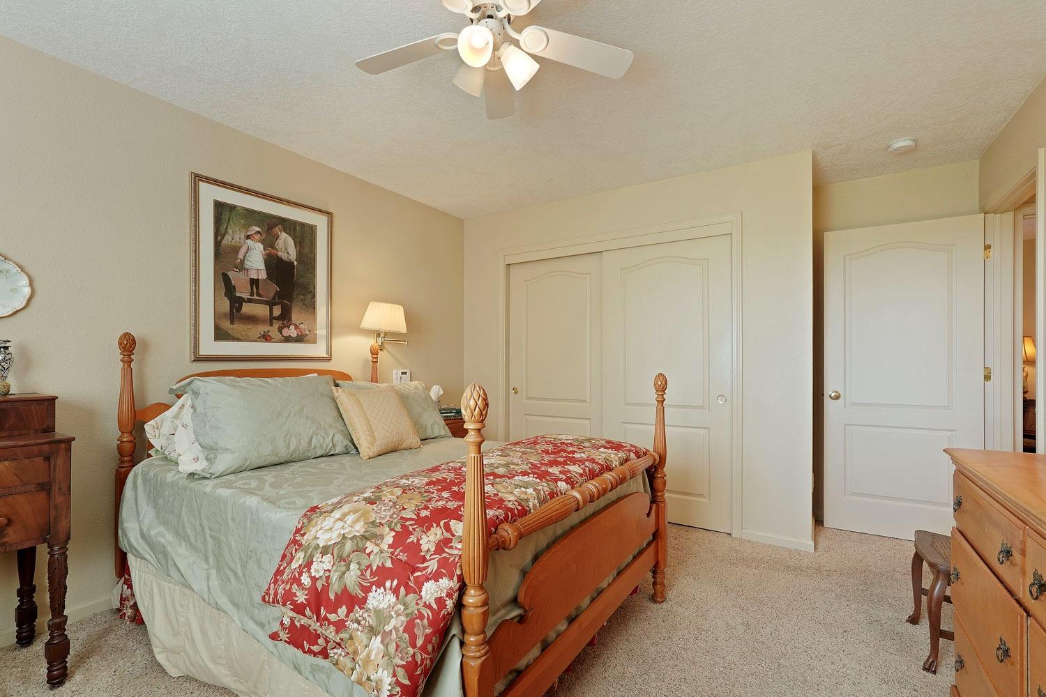 14267 East Peltier Road Acampo, CA 95220 - Photo 29 of 65 a bedroom with a bed and a chandelier