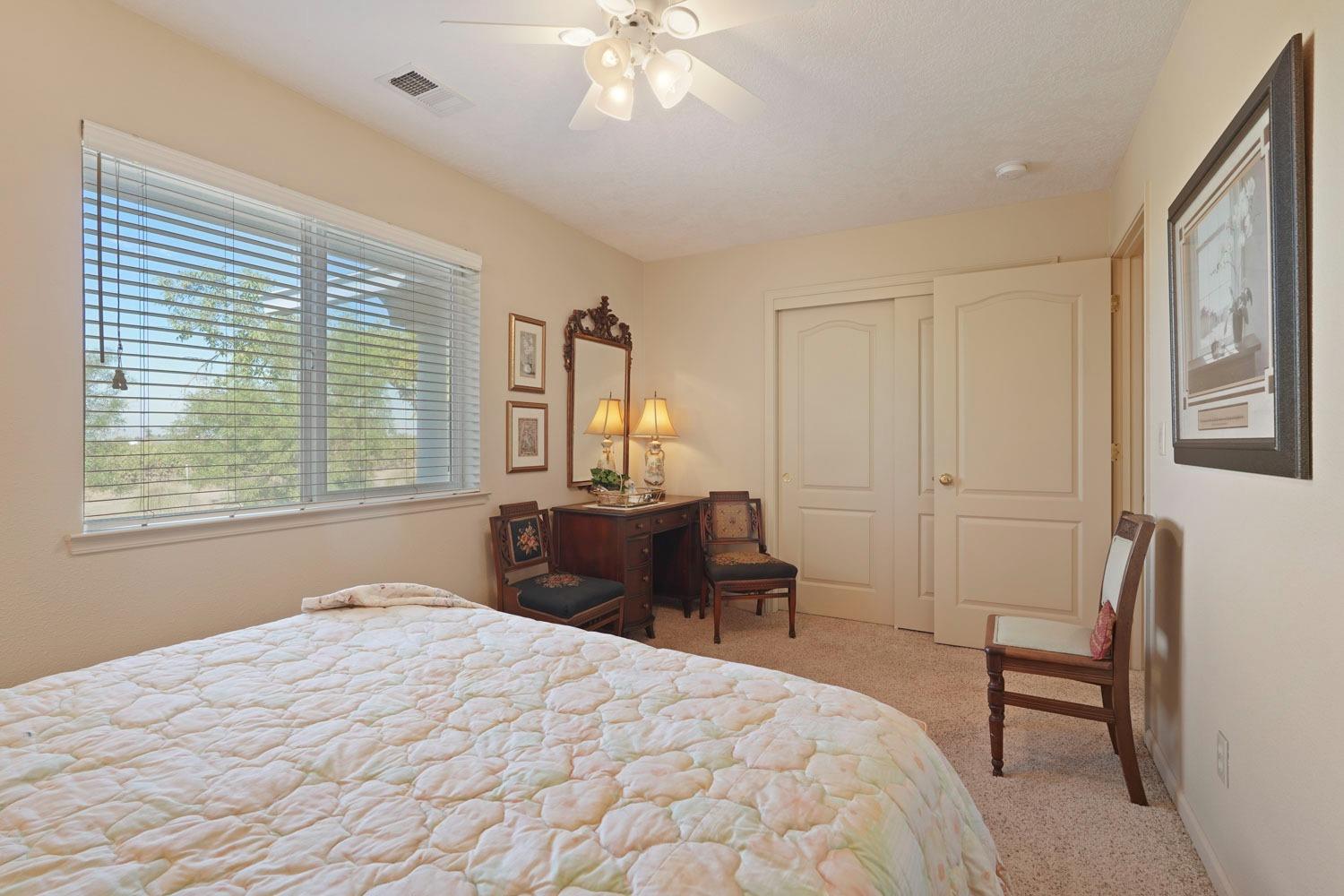 14267 East Peltier Road Acampo, CA 95220 - Photo 31 of 65 a bedroom with a bed and a chandelier