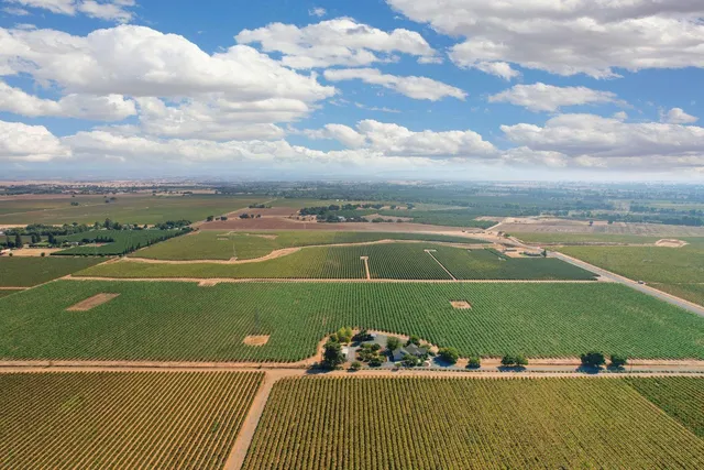 an aerial view of ocean and residential houses with outdoor space