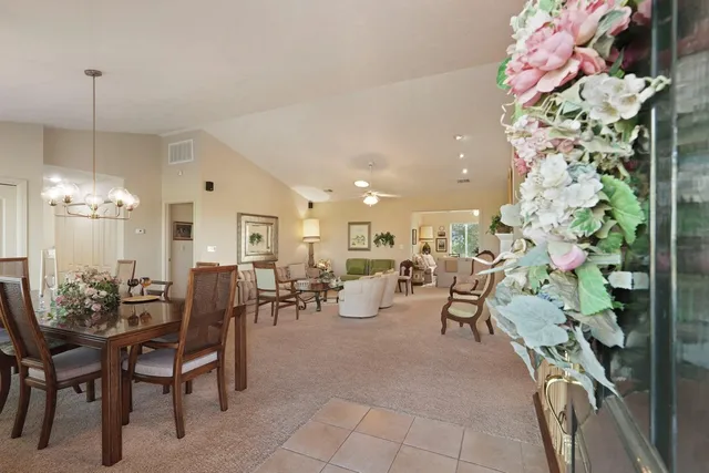a dining room with furniture a chandelier and window