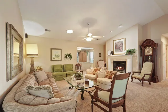a living room with furniture a fireplace and a large window
