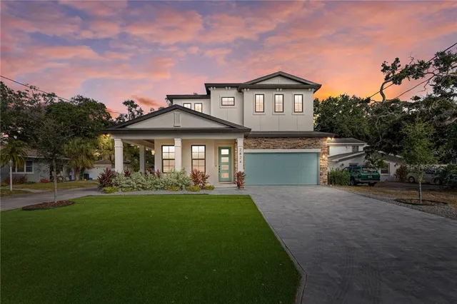 a front view of a house with a yard and trees