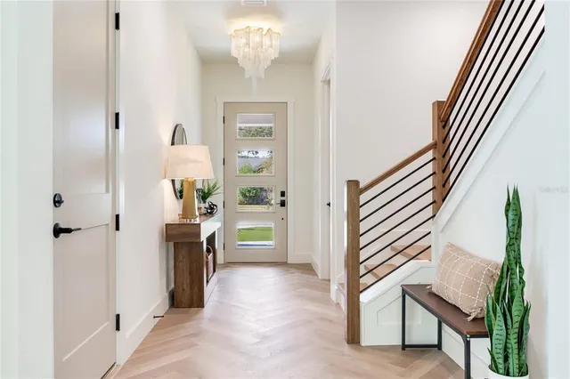 a view of a dining room with furniture a chandelier and wooden floor