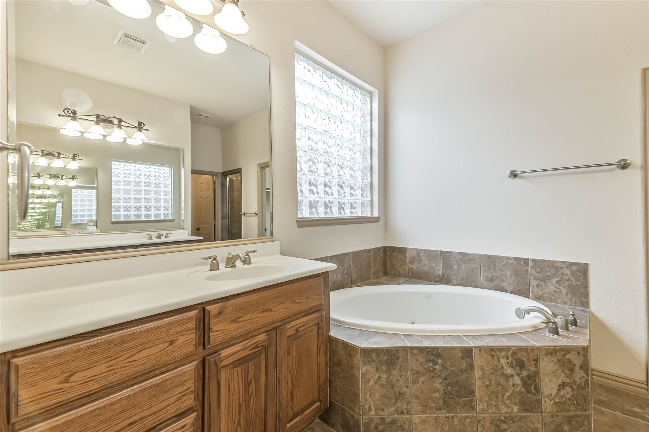 18743 Duke Lake Drive Spring, TX 77388 - Photo 20 of 46 a bathroom with a granite countertop sink a mirror and a bathtub