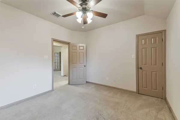 an empty room with closet and a chandelier fan