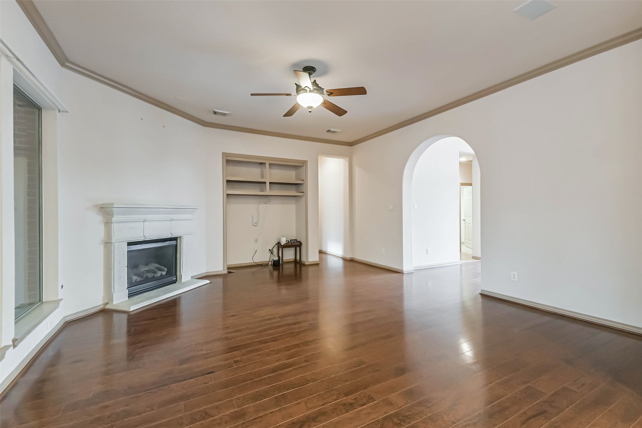 18743 Duke Lake Drive Spring, TX 77388 - Photo 8 of 46 an empty room with fireplace chandelier fan and windows